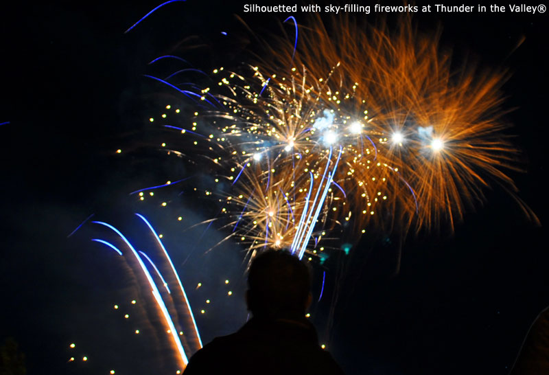 Silhouetted with sky-filling fireworks at Thunder in the Valley
